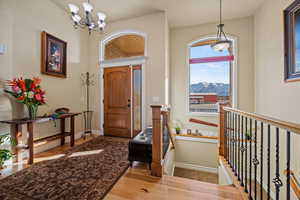 Entrance foyer featuring an inviting chandelier, a mountain view, and light hardwood / wood-style flooring