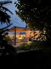 Exterior space featuring a pergola, a patio area, and an outdoor living space with a fire pit