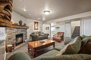 Carpeted living room featuring a fireplace and a textured ceiling