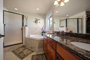 Bathroom with tile patterned floors, separate shower and tub, and vanity