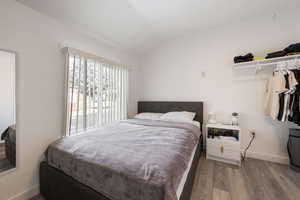 Bedroom featuring vaulted ceiling and light hardwood / wood-style flooring