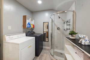 Laundry room featuring light wood-type flooring and independent washer and dryer