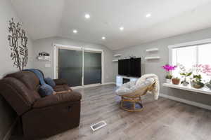 Living room with light hardwood / wood-style flooring and lofted ceiling