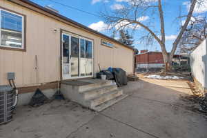 View of exterior entry featuring cooling unit and a patio area