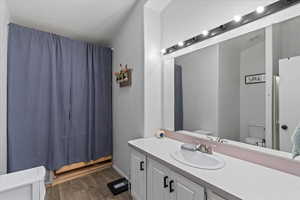 Bathroom with toilet, vanity, and hardwood / wood-style floors