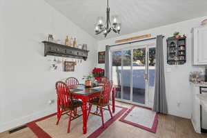 Dining space featuring lofted ceiling, light wood-type flooring, and a chandelier