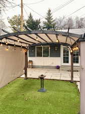 Back of house with a patio and a yard