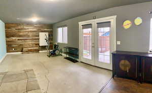 Interior space with fridge, wood walls, and french doors