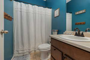 Bathroom featuring toilet, vanity, and tile patterned floors