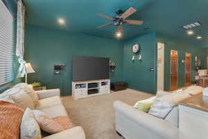 Carpeted living room with ceiling fan