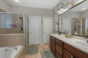 Bathroom featuring plus walk in shower, tile patterned flooring, and vanity