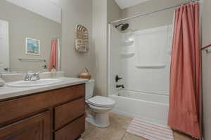 Full bathroom with toilet, tile patterned flooring, shower / bath combo, and vanity