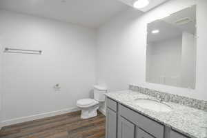 Bathroom with toilet, vanity, and hardwood / wood-style floors