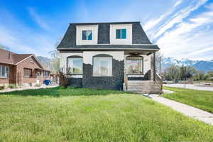 View of front of house featuring a mountain view and a front lawn