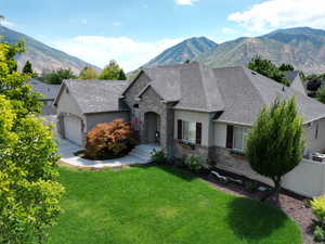 French country style house with a garage, a mountain view, and a front yard