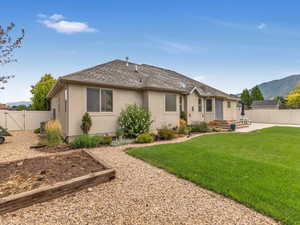 Rear view of house featuring a patio area, a mountain view, and a yard