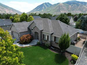 View of front of home with a garage, central AC, a mountain view, and a front yard