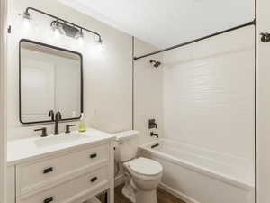 Full bathroom with toilet, vanity, wood-type flooring, and shower / bathing tub combination