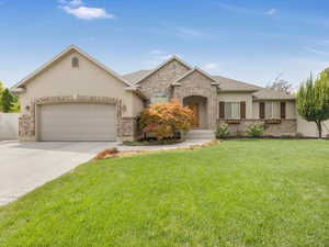 View of front of property with a front yard and a garage