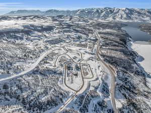 Snowy aerial view featuring a water and mountain view