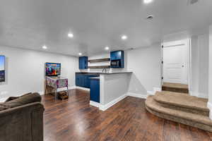 Theater room with wet bar under suspended slab garage.