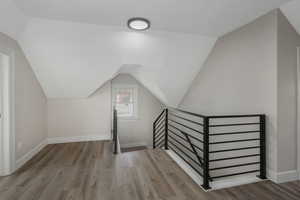 Bonus room with vaulted ceiling and light hardwood / wood-style floors