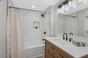 Bathroom with vanity and shower / bathtub combination with curtain