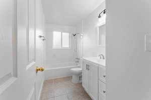 Full bathroom featuring toilet, shower / bath combination, tile patterned floors, and vanity