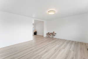 Empty room with light hardwood / wood-style floors