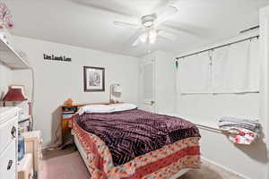 Bedroom with ceiling fan and light carpet