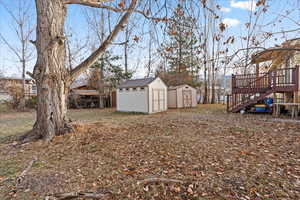 View of yard featuring a storage unit and a wooden deck