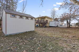 Exterior space featuring a deck and a storage unit