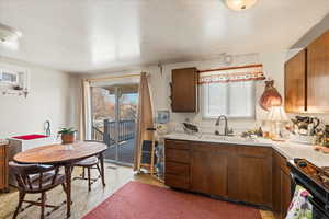 Kitchen with a wealth of natural light, black & white stove, and sink