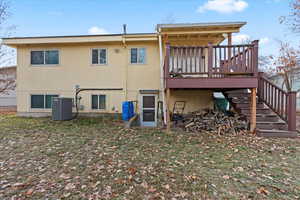 Rear view of house with a deck and central air condition unit