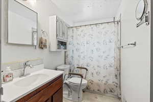 Full bathroom featuring toilet, vanity, and shower / bath combination with curtain