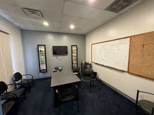 Office featuring dark carpet and a paneled ceiling