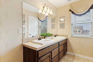 Bathroom #5 with vanity, a chandelier, and tile patterned flooring