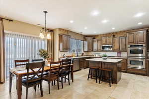 Kitchen with a center island, decorative light fixtures, stainless steel appliances, tasteful backsplash, and a notable chandelier