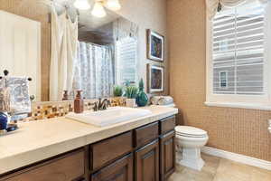 Bathroom featuring toilet, vanity, and tile patterned flooring