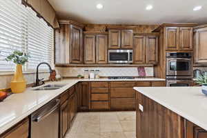 Kitchen with sink, appliances with stainless steel finishes, and tasteful backsplash