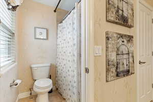 Bathroom #5 with toilet, tile patterned floors, and curtained shower