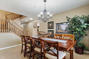 Carpeted dining room with a notable chandelier