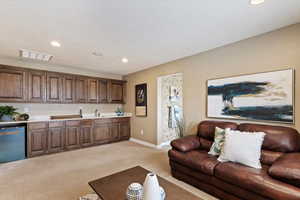 Primary suite living room featuring light colored carpet and sink