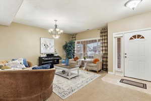 Living room with light colored carpet and a chandelier