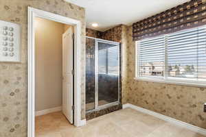 Primary suite bathroom #2 featuring a shower with door and tile patterned flooring