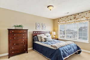 Bedroom #4 featuring light carpet and a textured ceiling