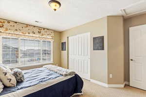 Carpeted bedroom #4 with a textured ceiling and a closet