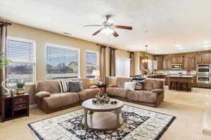 Family room  with a healthy amount of sunlight, light tile patterned floors, sink, and ceiling fan with notable chandelier