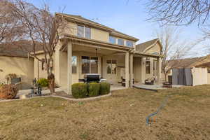 Rear view of house featuring an outdoor fire pit, a lawn, and a patio