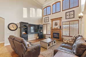 Living room with crown molding, a high ceiling, and a tile fireplace